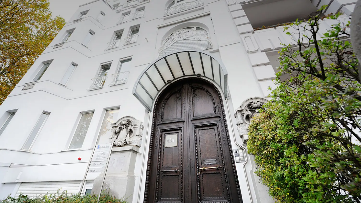 Portal der Klinik am Rhein in Düsseldorf-Oberkassel mit dunkler Holztür