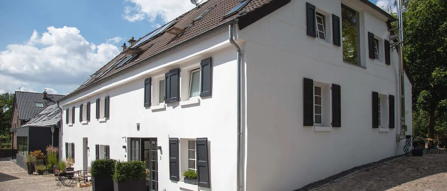 Die Praxis Schönheitsmühle in Ratingen, ein weiß gekalktes Mühlengebäude am Kopfsteinhof